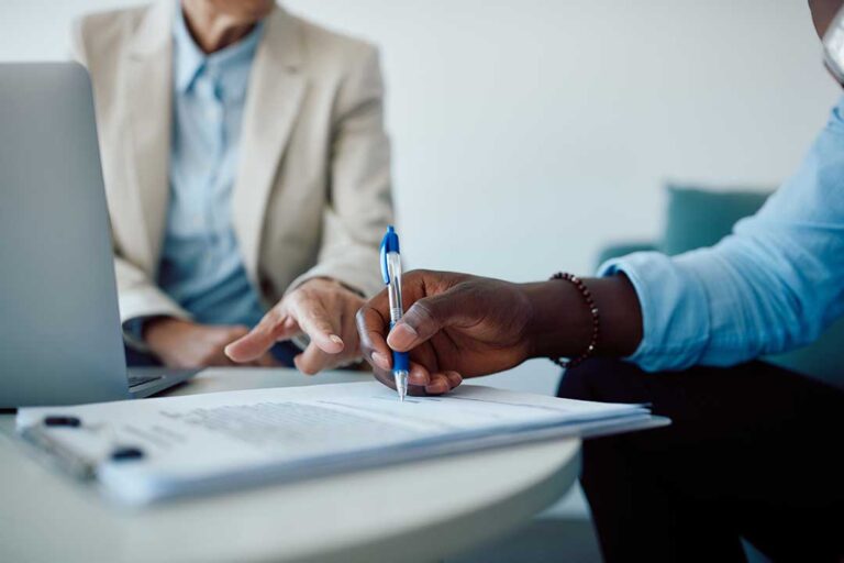 A family sitting together at a kitchen table, reviewing insurance documents and discussing coverage options.